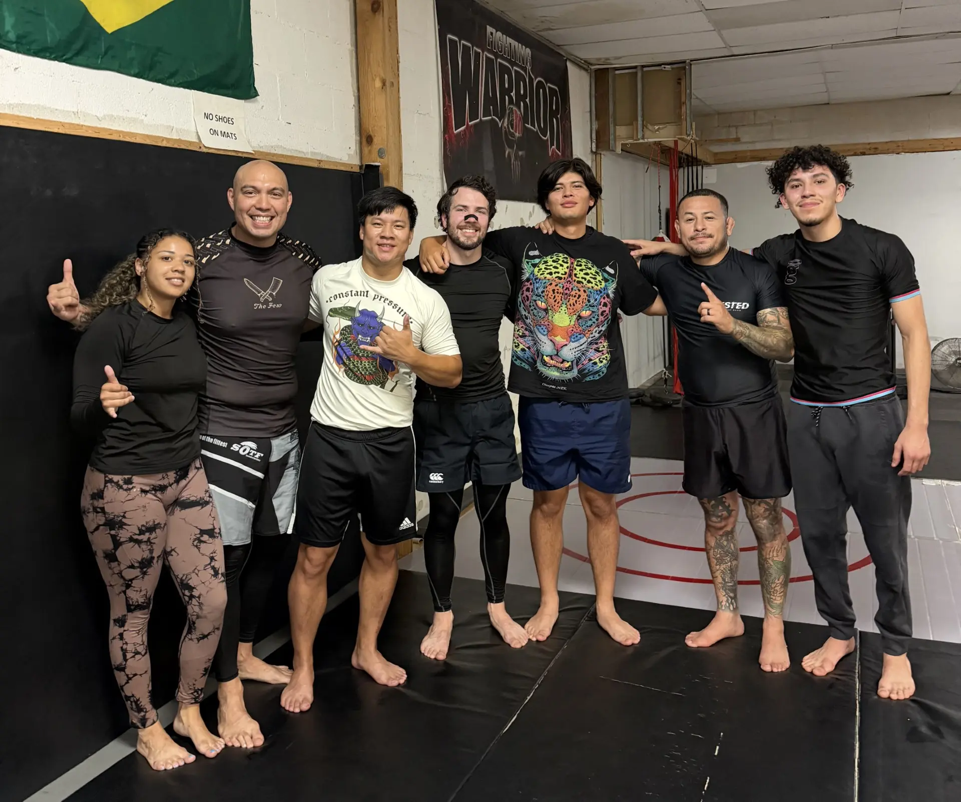 Guardians Grappling Academy members smiling together on the mats after class